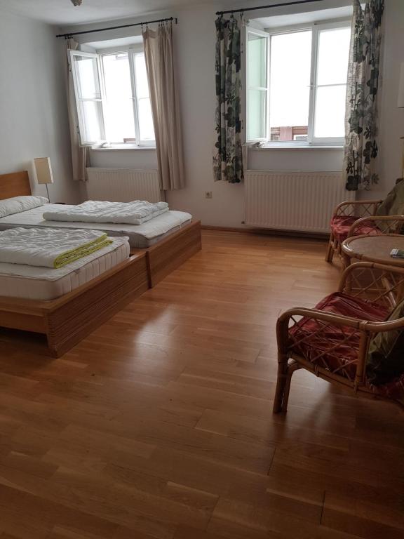 因斯布鲁克Hostel in der Altstadt NepomukB&B的一间卧室配有两张床、椅子和两个窗户。
