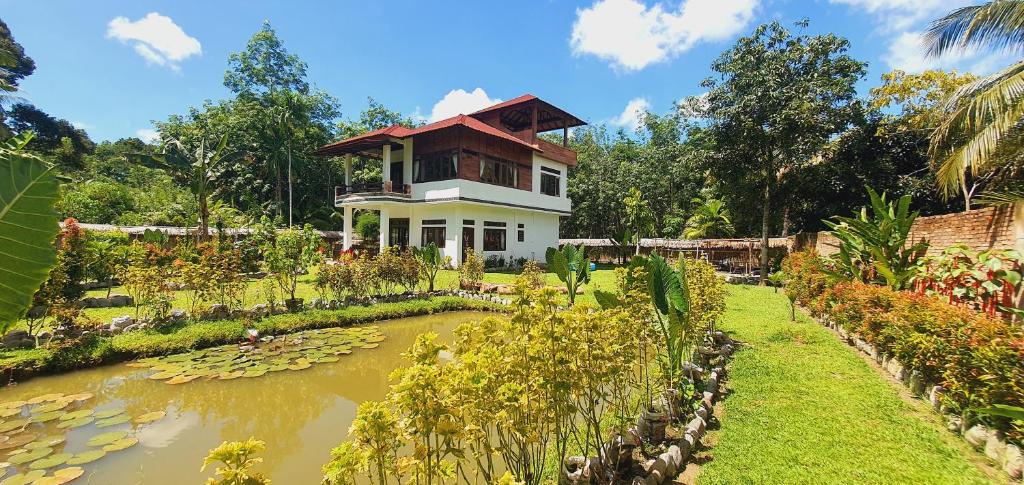 武吉拉旺Villa Cheeky Monkeys的前面有池塘的房子