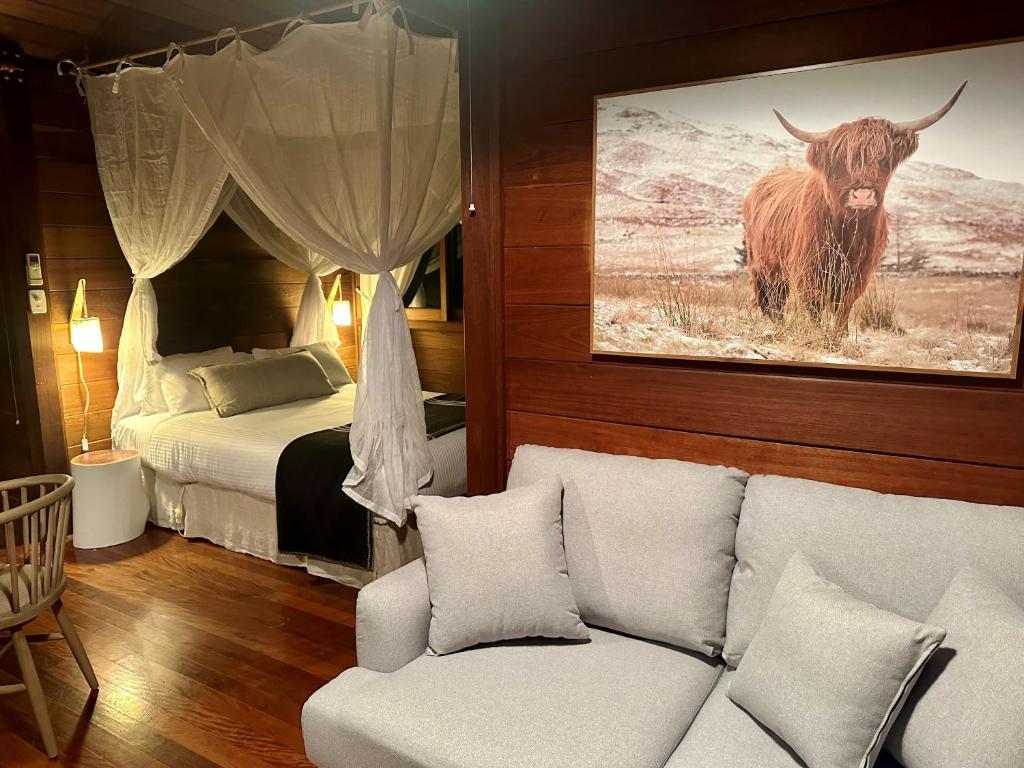贝林真Koompartoo Retreat Bellingen的客厅配有沙发和一公牛床