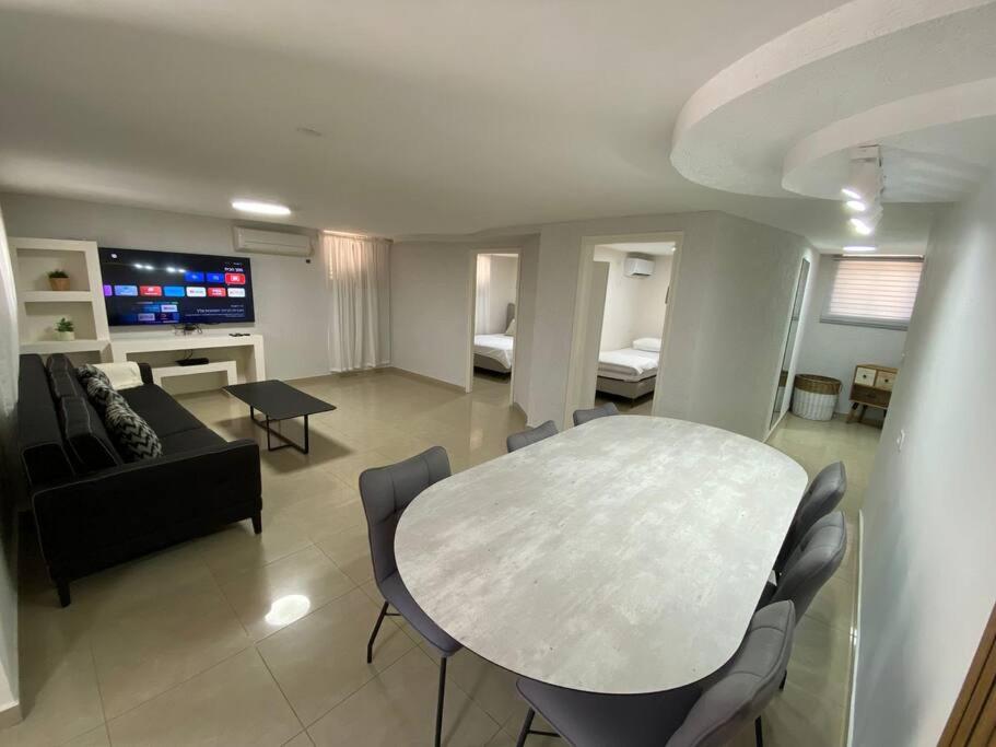 谢莫纳城יחידת קורל בלב הגליל העליון coral unit的客厅配有桌子和沙发