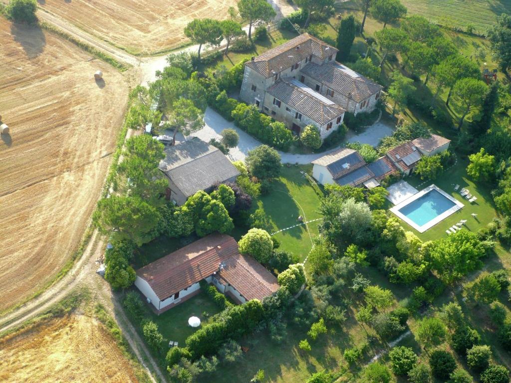 阿夏诺Chic Farmhouse in Asciano Italy with Swimming Pool的享有大房子空中美景,设有庭院