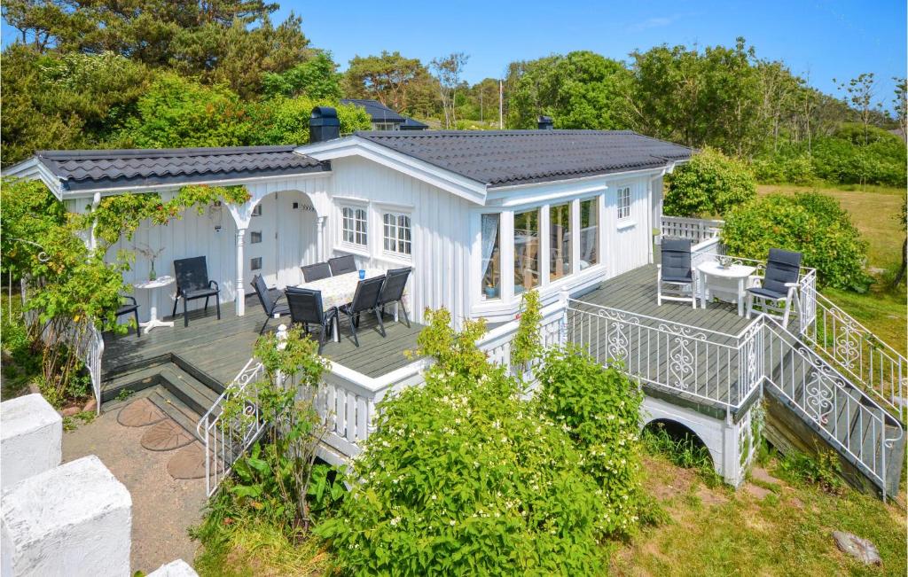 阿伦达尔Beach Front Home In Frvik With House Sea View的白色的房子,配有带桌椅的甲板