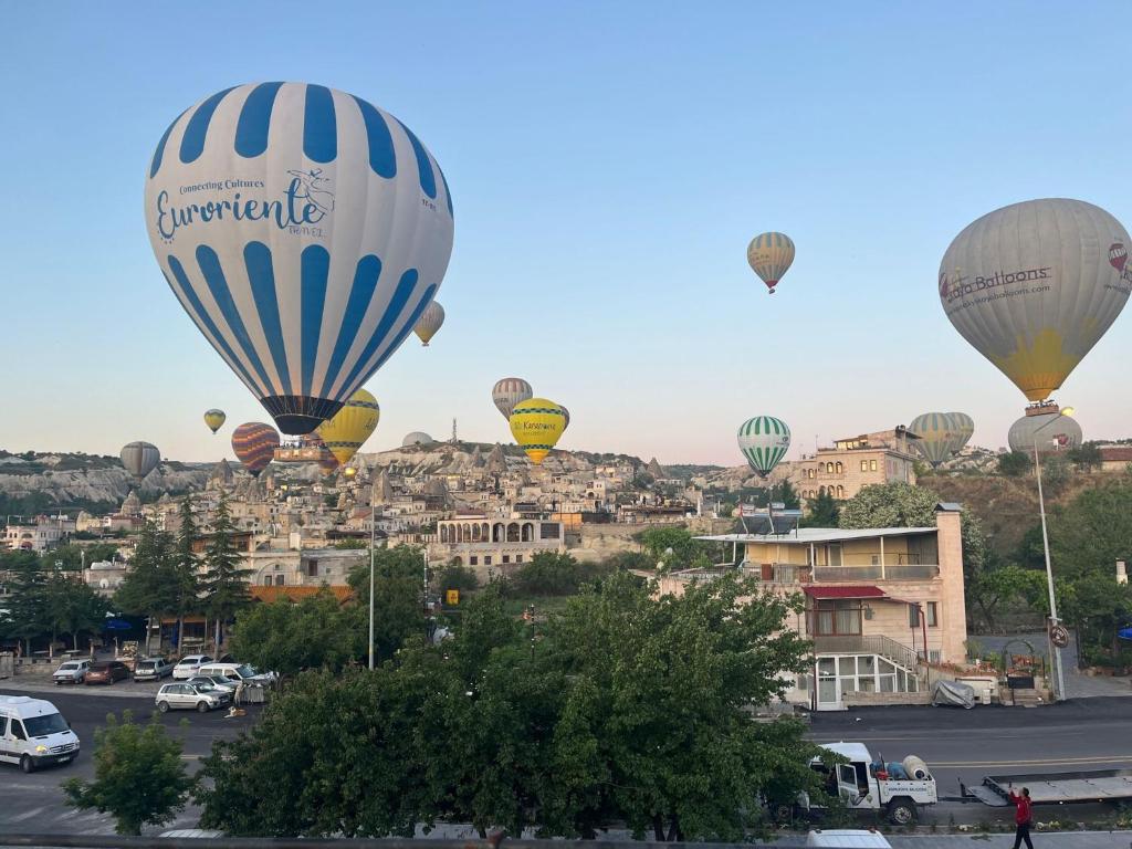 格雷梅Adventure Inn Cappadocia的一群热气球飞越城市