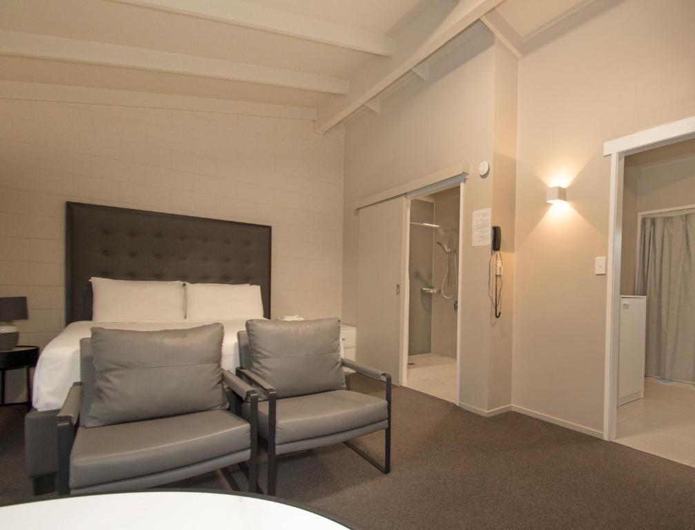 奥克兰梅朵茂汽车旅馆的一间卧室配有一张床和两把椅子
