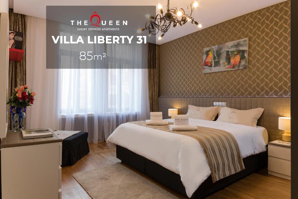卢森堡女王豪华公寓 - 自由别墅的酒店客房设有一张大床和吊灯。