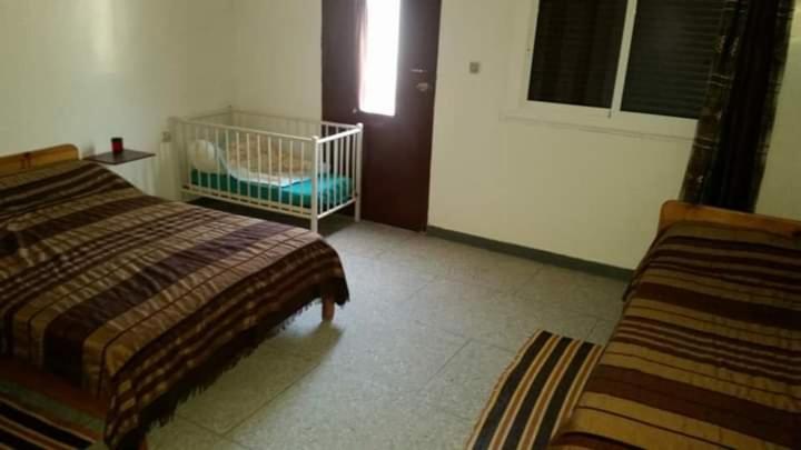 艾西拉ESCAPADE Assilah的一间卧室配有两张床和一张婴儿床。