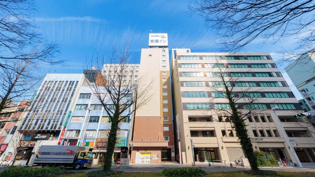 名古屋Toyoko Inn Nagoya Sakae的前面有树木的高楼
