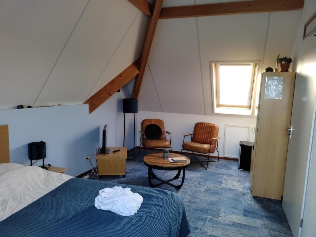 Baaiduinen海燕酒店的卧室配有一张床和一张桌子及椅子