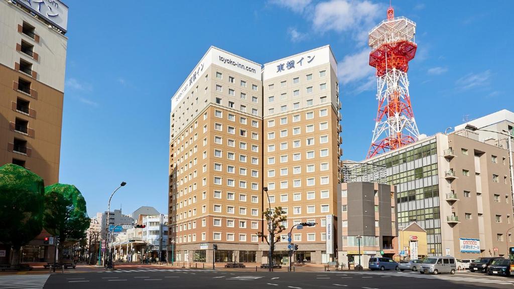 平冢市Toyoko Inn Shonan Hiratsuka eki Kita guchi No 1的一座高大的建筑,上面有一座塔