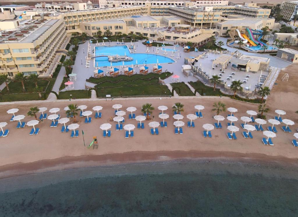 赫尔格达Aqua Mondo Abu Soma Resort的享有带游泳池和遮阳伞的度假村的空中景致