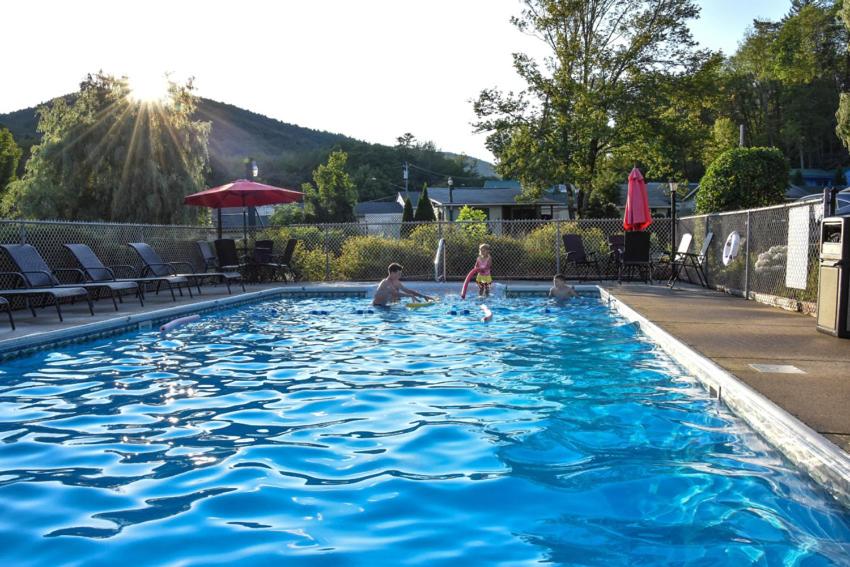 乔治湖Adirondack Sunrise Lodge的男人和孩子在游泳池玩耍