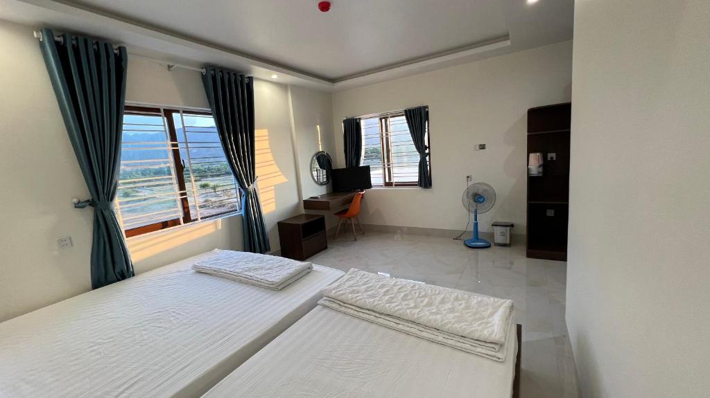 My LuongKhách sạn Thiên Minh - Dốc Lết的一间卧室设有两张床和窗户。