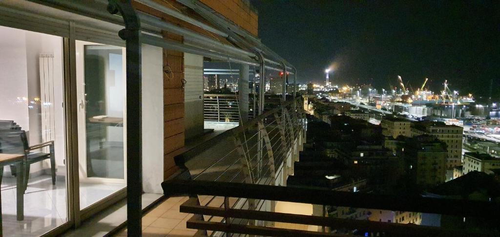 热那亚Attico con Vista su Genova的阳台,晚上可欣赏到城市景观