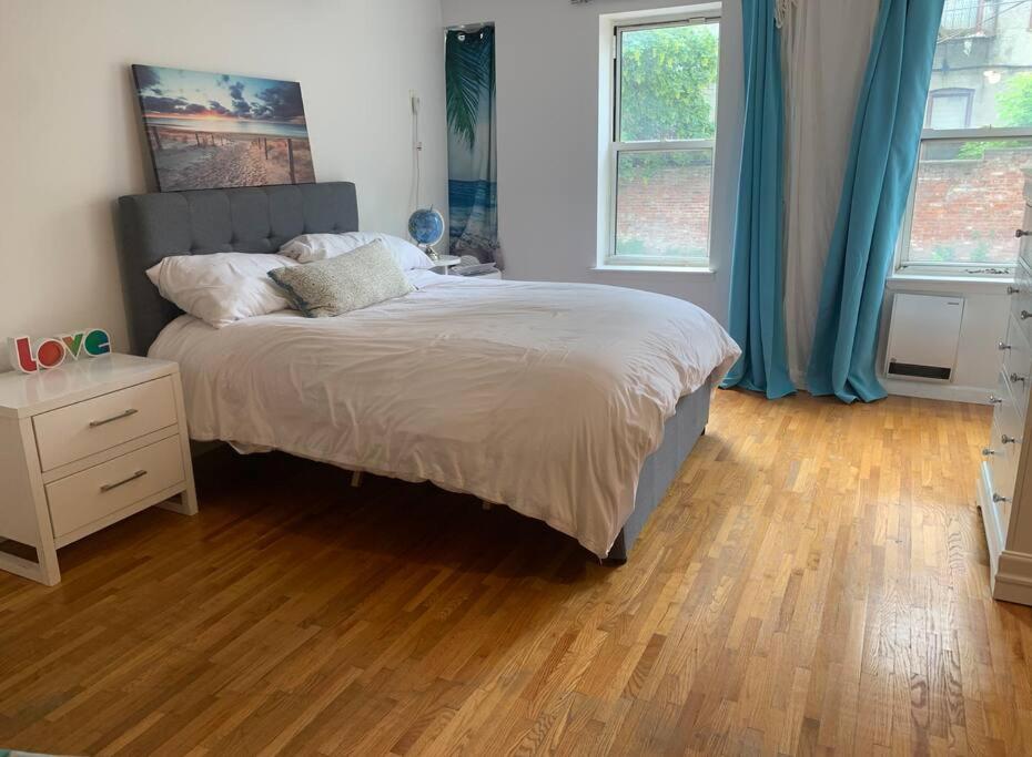 布鲁克林Crown Heights Gem的一间卧室配有一张床,铺有木地板