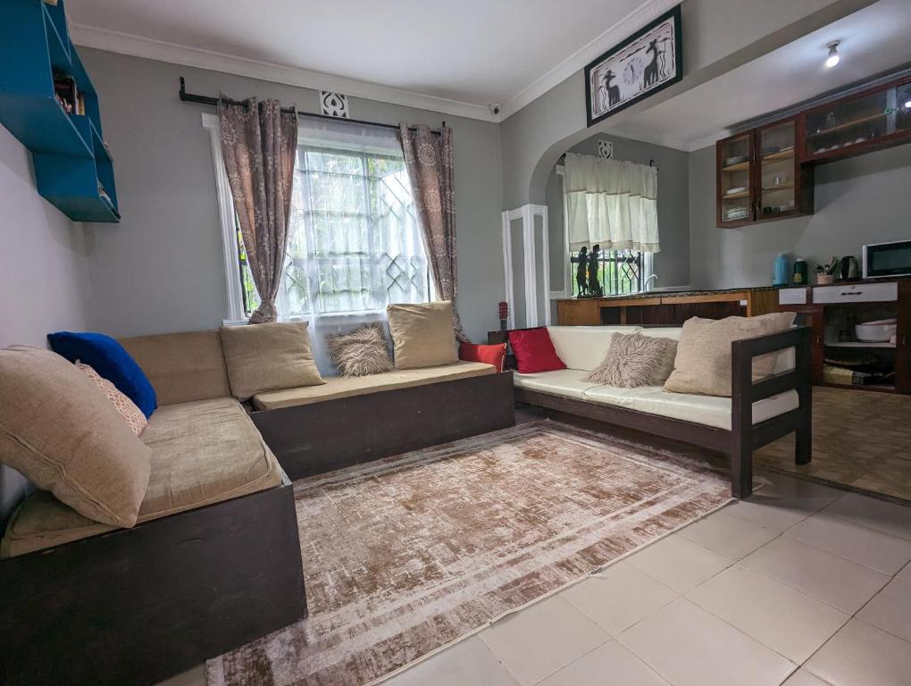 阿鲁沙Elizabeth Home的客厅配有沙发和桌子