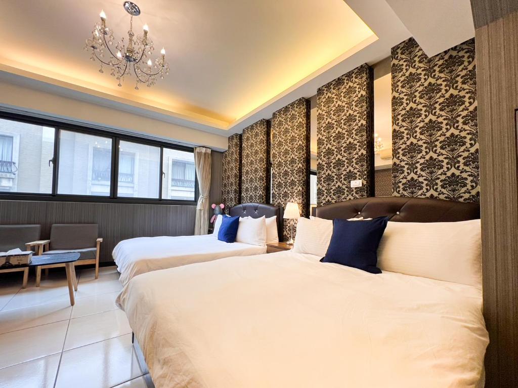 台中市一中小窩馨的酒店客房设有两张床和吊灯。