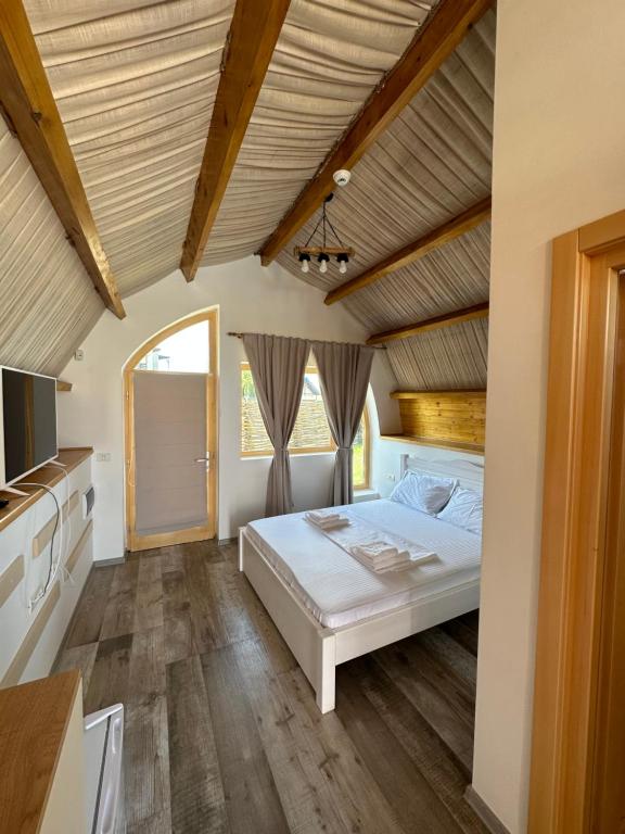 穆里吉奥尔Complex Andris的卧室设有白色的床和木制天花板。