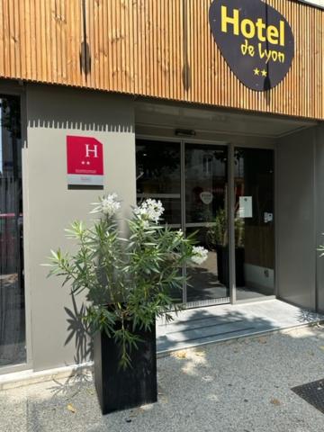 瓦朗斯里昂酒店的建筑前有植物的酒店