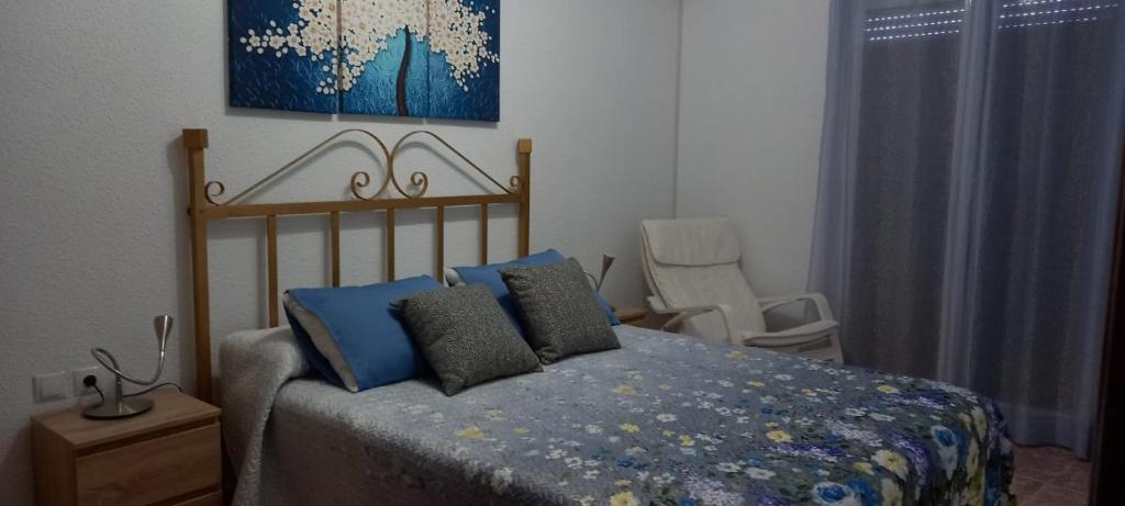 拉瓜迪亚Apartamento Sevilla 3的一间卧室配有一张床和一把椅子