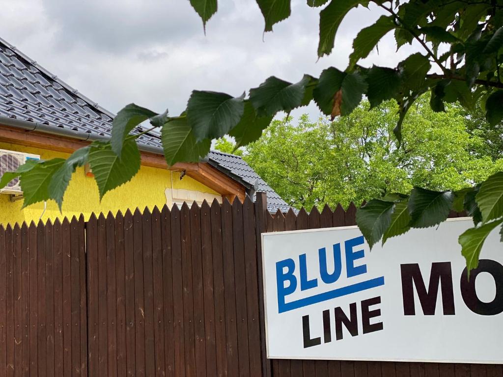 亚斯贝雷尼Blueline Motel的房屋前的栅栏上的一个蓝色的林荫标志