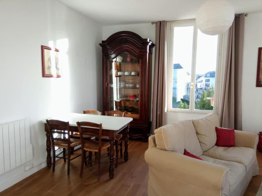 希农Le Nid de L’Île的客厅配有桌子和白色沙发