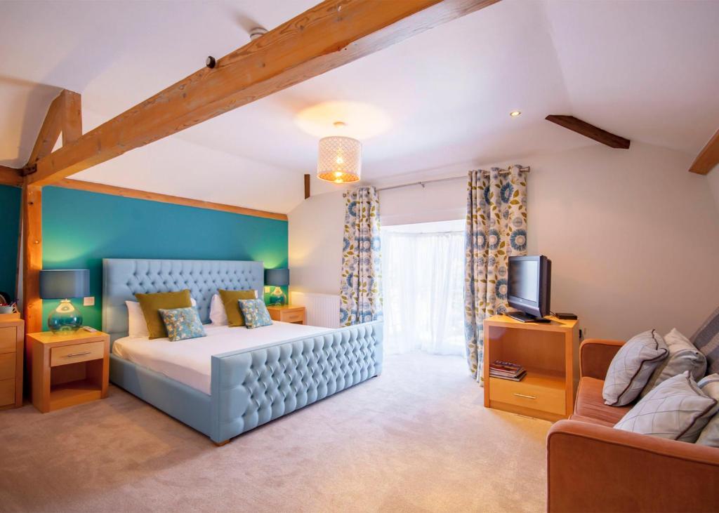 史云顿海沃思酒店的一间卧室配有一张床、一张沙发和一台电视。