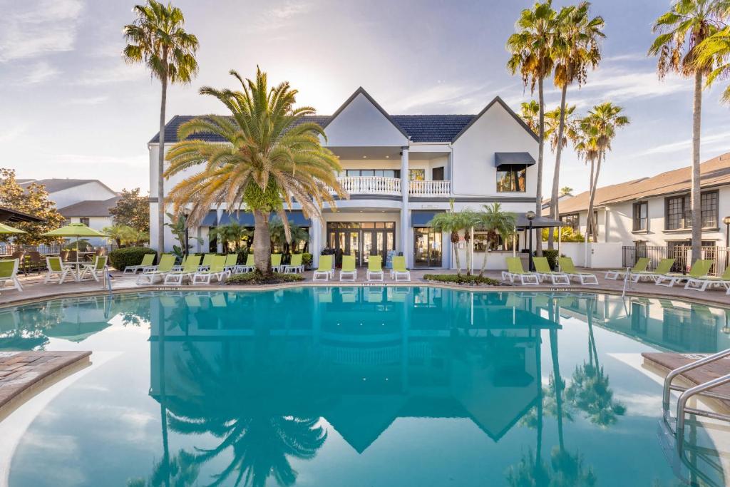 基西米Legacy Vacation Resorts Kissimmee & Orlando - Near Disney的棕榈树屋前的游泳池