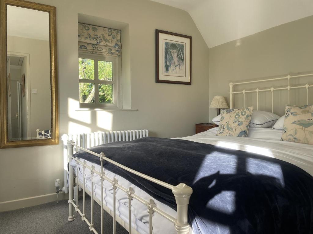 莱德林赫The Old Coach House的卧室配有白色的床和窗户。