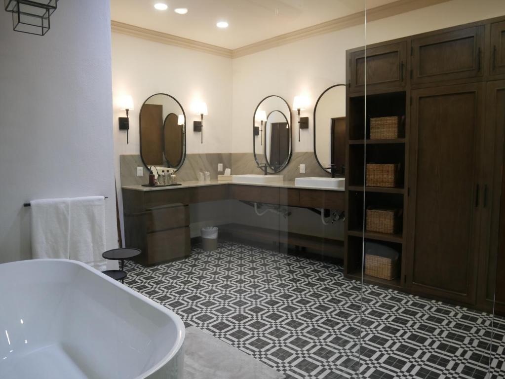 帕拉斯德拉富恩特Hotel El Farol的带浴缸、两个盥洗盆和镜子的浴室