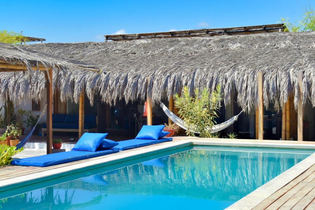 维加伊托Casa Lodge (primera fila)的一个带游泳池和茅草屋顶的度假胜地
