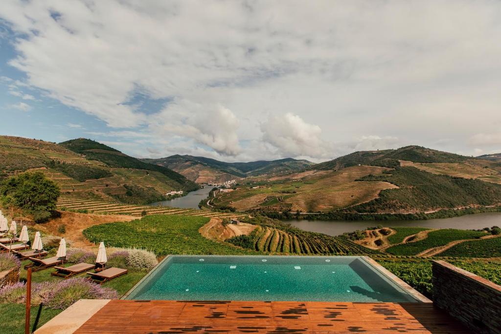 Ervedosa do DouroVentozelo Hotel & Quinta的享有河流和山脉景色的游泳池