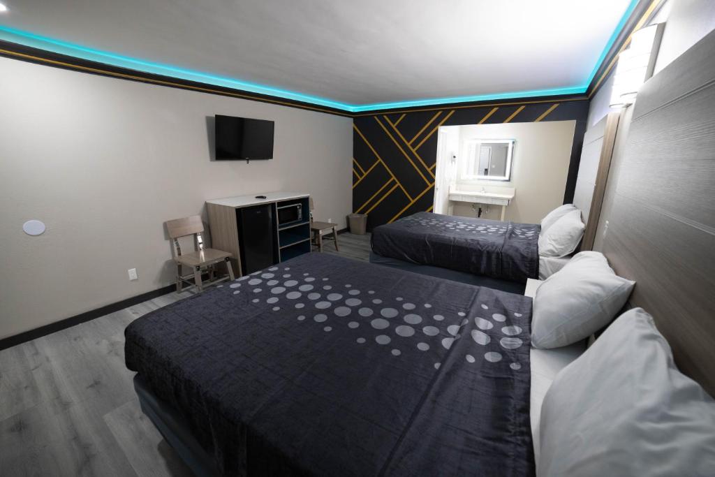 贝尔弗劳尔Artesia Motor Inn的酒店客房设有两张床和电视。