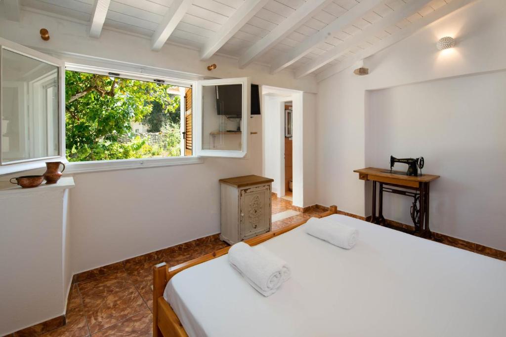 VelianitátikaAphrodite's hidden gem on Paxos island的一间卧室设有两张床和窗户。