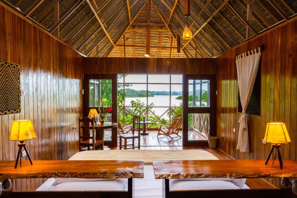 马尔多纳多港Sotupa Eco Lodge的一间带桌椅的客厅和一个庭院