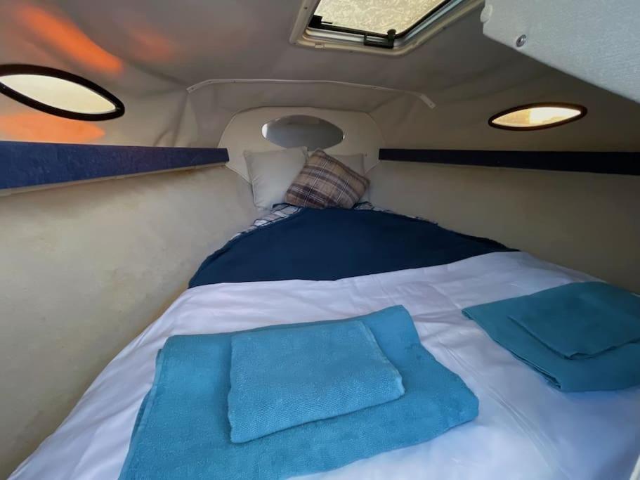 法鲁GuestBoat Milagre的一张位于带两个枕头的面包车后面的床铺