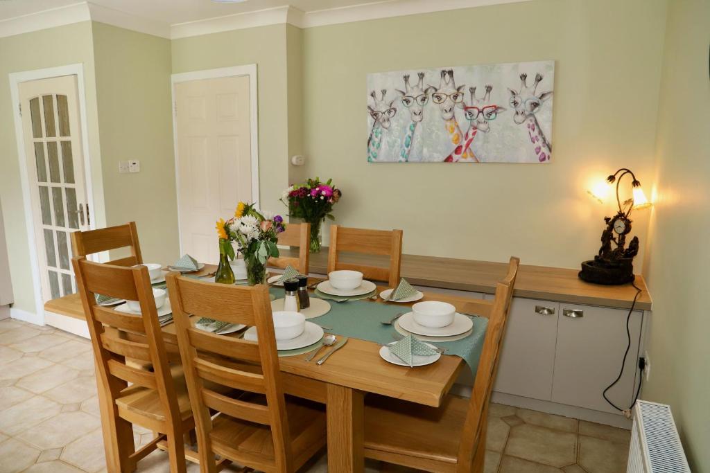 基洛格林Centrally located house on Ring of Kerry的一间带木桌和椅子的用餐室
