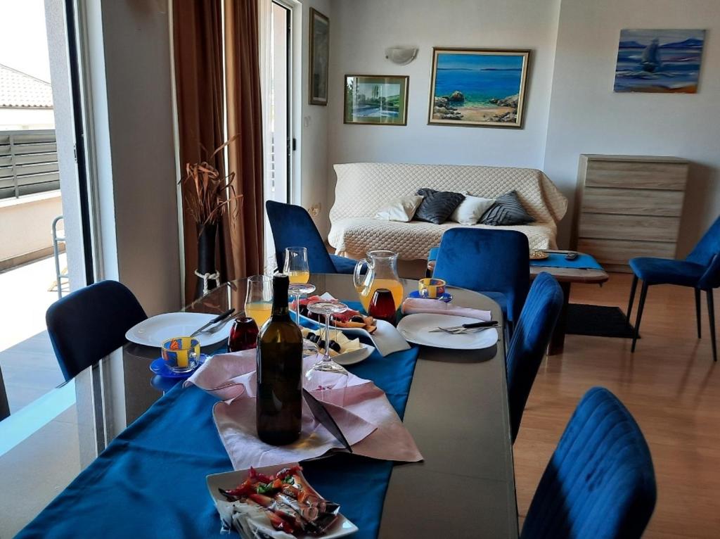 巴什卡沃达The One的客厅配有桌子和蓝色椅子