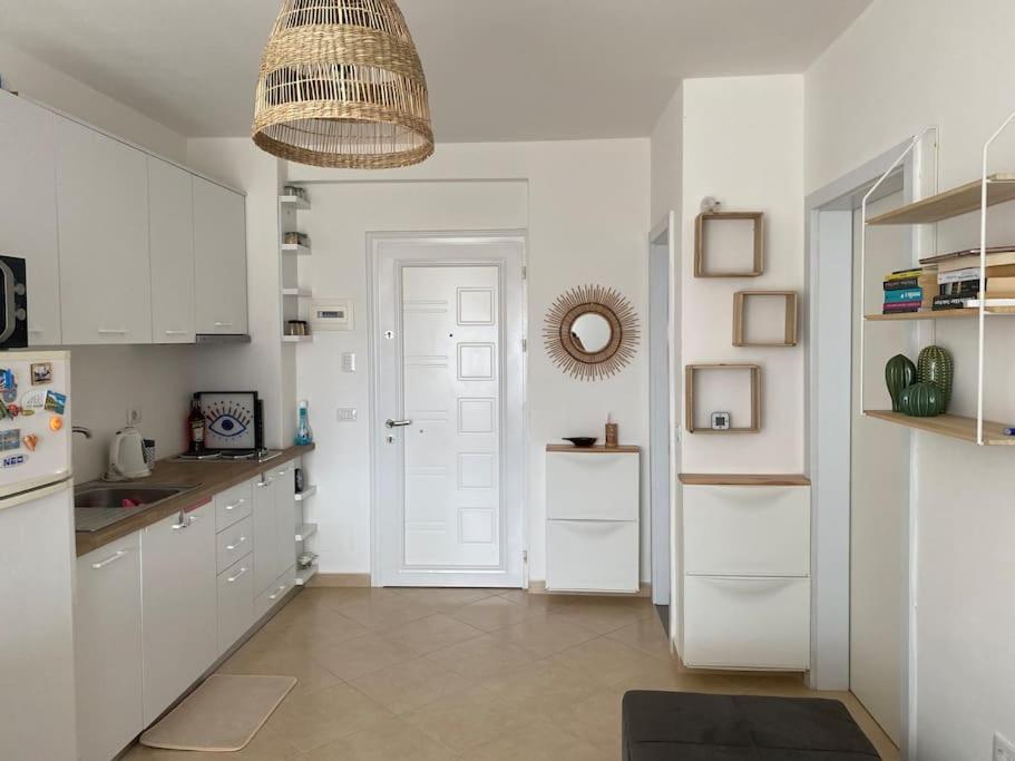 圣金The Flip-Flop Apartment的厨房配有白色橱柜和白色门
