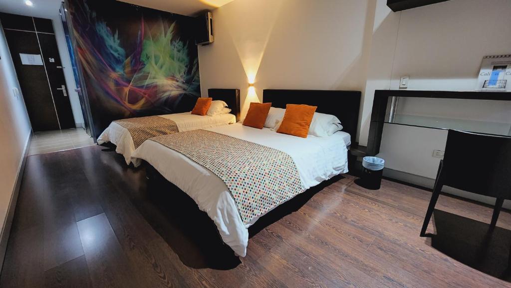 卡利Hotel Austral Suites的一间卧室设有两张床,墙上挂着一幅画