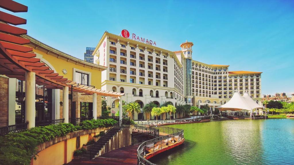 惠州Ramada By Wyndham Huizhou South的享有酒店和河流的景色,拥有建筑
