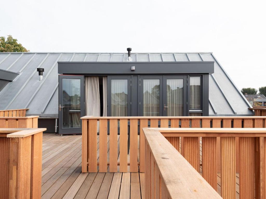 雷讷瑟Luxury apartment in Renesse with infrared sauna的一座带黑色屋顶木甲板的房子