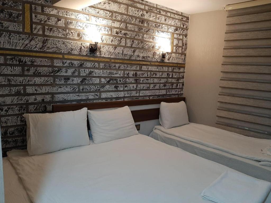 卡尔斯Hotel kafkasya的一间卧室设有一张床和砖墙