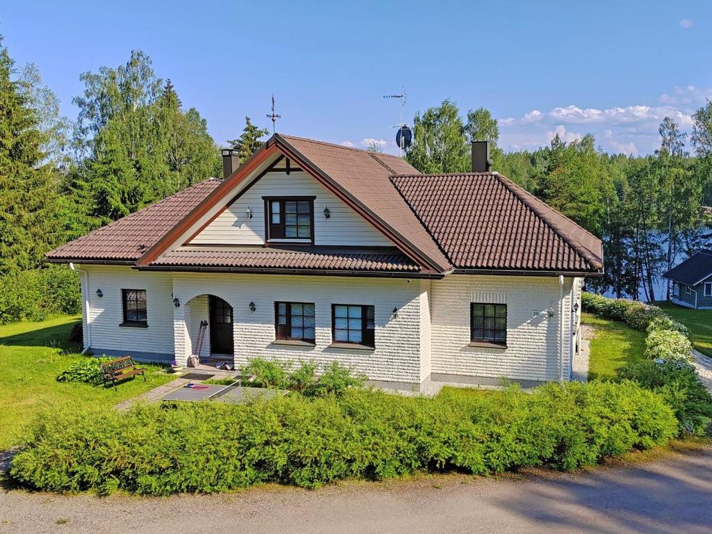 曼蒂哈尔尤Villa Grinberg的白色房子,有棕色的屋顶