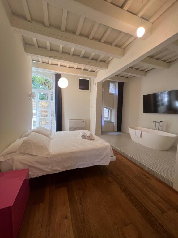 乌尔比诺Urbino Apartment - Torricini View的一间卧室配有一张床、一个浴缸和一个水槽