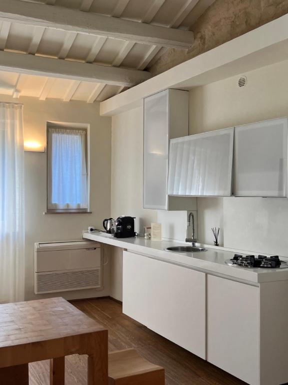 乌尔比诺Urbino Apartment - Urban Retreat的厨房配有白色橱柜和桌子