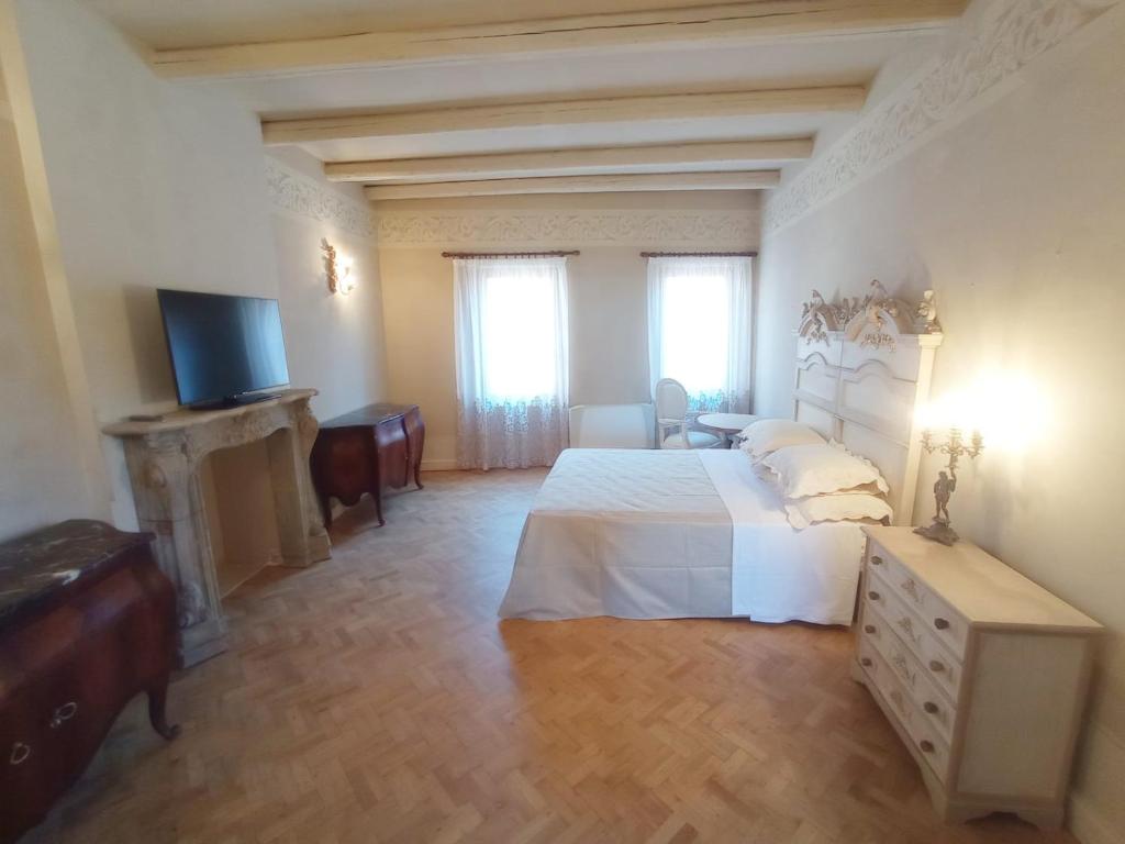 阿夸维瓦皮切纳Hotel Oviv dimora del borgo的一间大卧室,配有一张床和一台电视