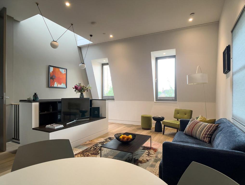 伦敦Mirabilis Apartments - Bayham Street的带沙发和电视的客厅