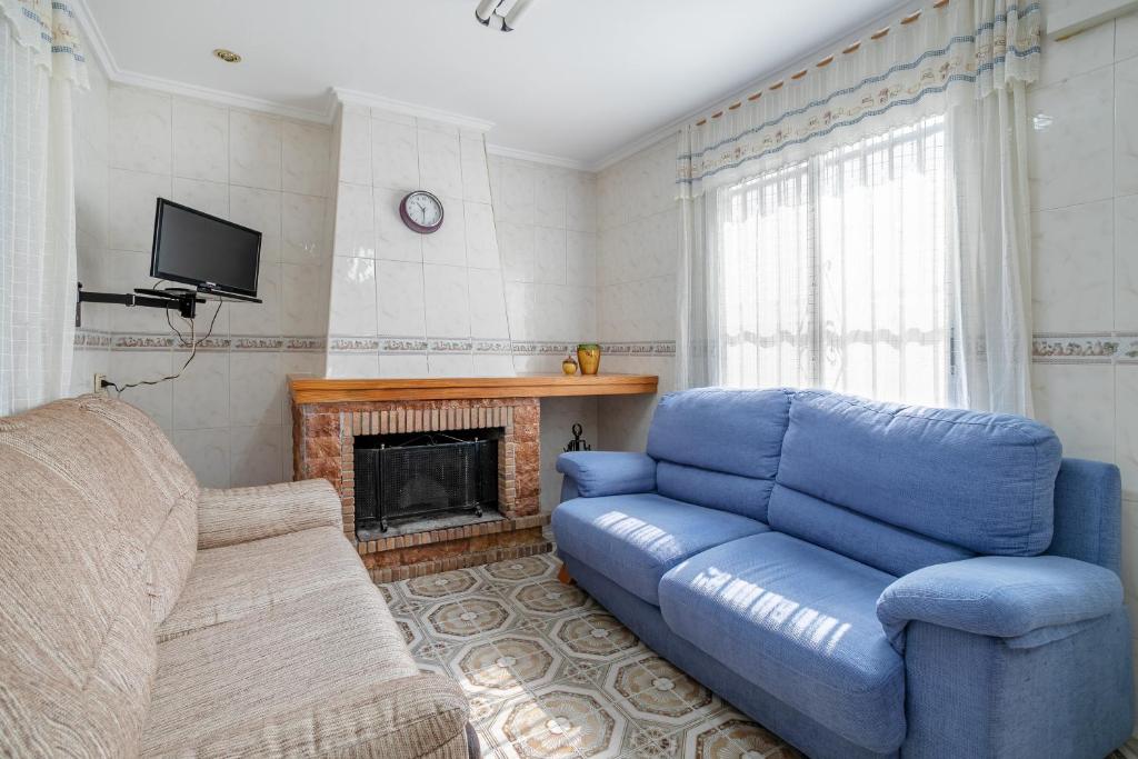 Caserío BacarotGeranio的客厅设有蓝色的沙发和壁炉