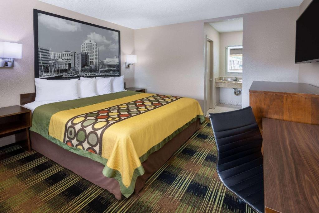 威廉斯堡威廉斯堡历史区速8酒店的酒店客房设有一张大床和一张书桌。