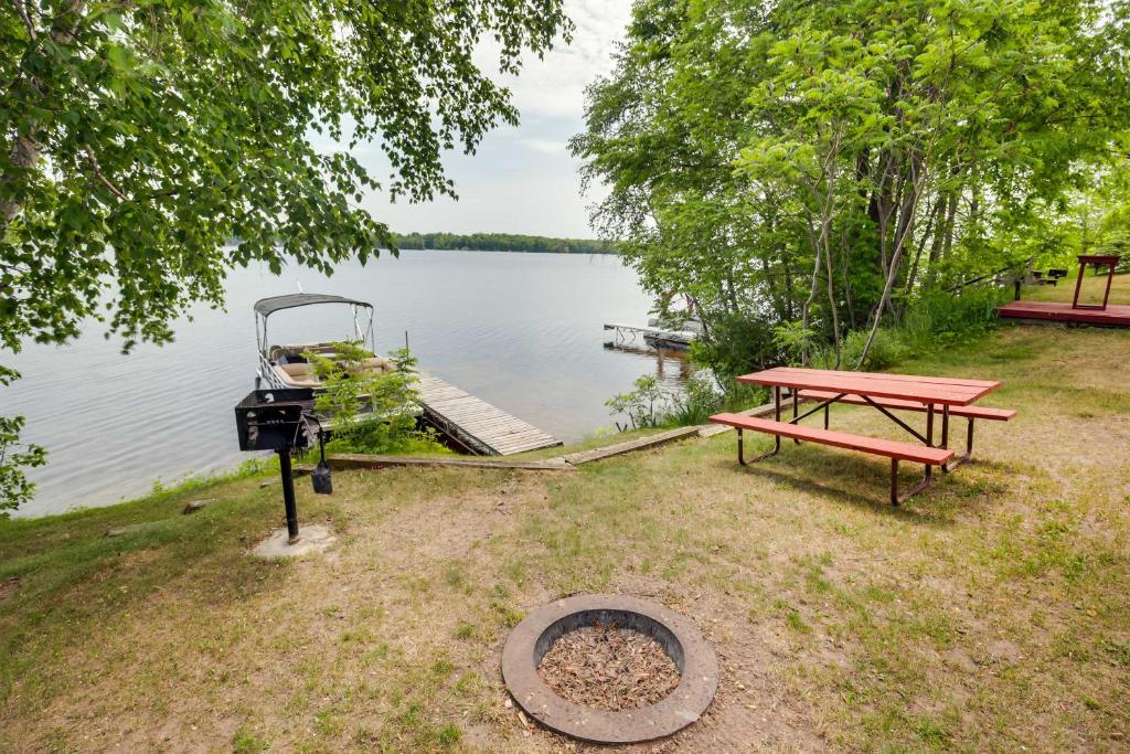 Pet-Friendly Wisconsin Cabin on Lake with Fire Pit!的湖畔野餐桌和烧烤架